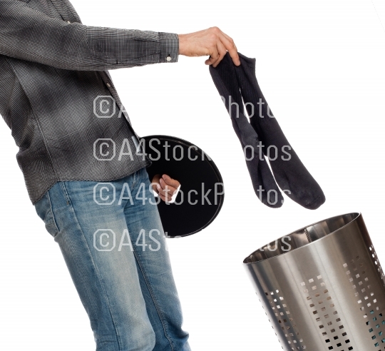 Young man putting dirty socks in a laundry basket