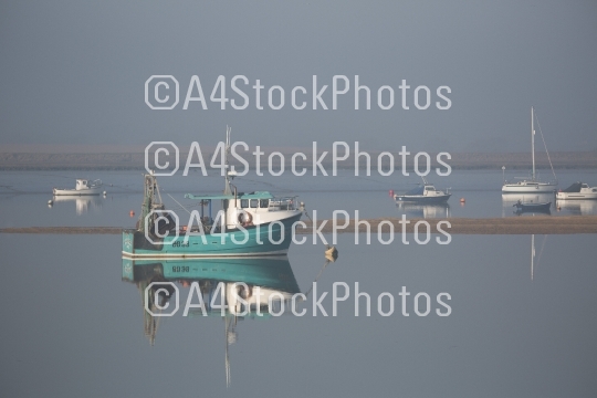 Fishing boats at anchor in the fog