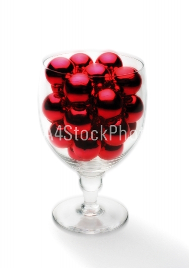 Red Christmas baubles in a wine glass