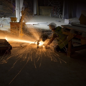 A workman using a disc cutter on a large construction site