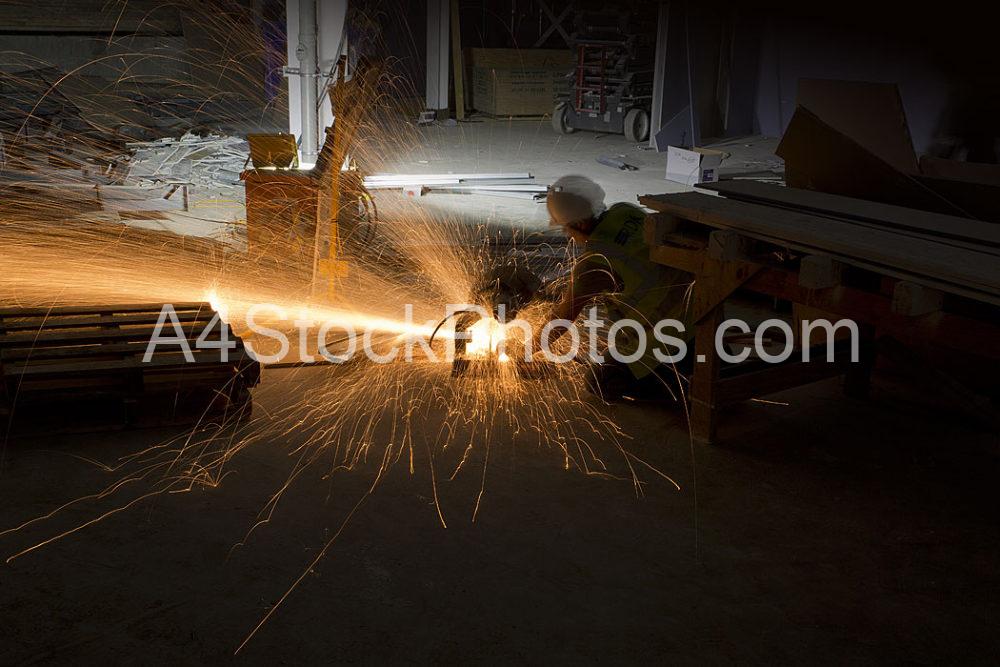 A workman using a disc cutter on a large construction site