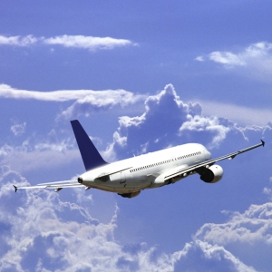 A jet airliner flying off into the wide blue sky