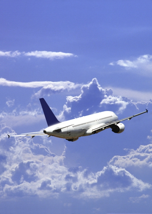 A jet airliner flying off into the wide blue sky