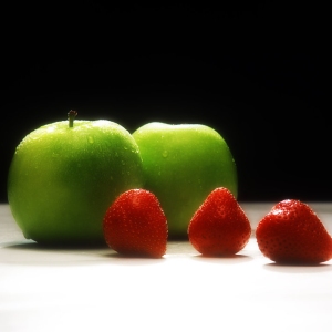 Apples and strawberries against a black background