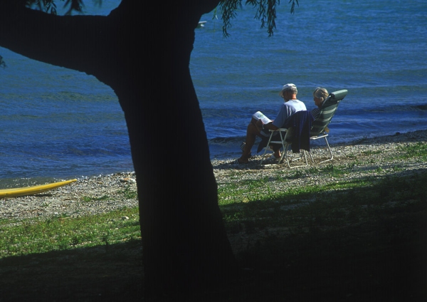 A middle aged couple relaxing on the shores of Lake Como in Italy