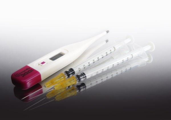 A digital thermometer and disposable syringes