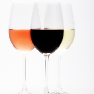 Three wine glasses containing, red, white and rosé wine