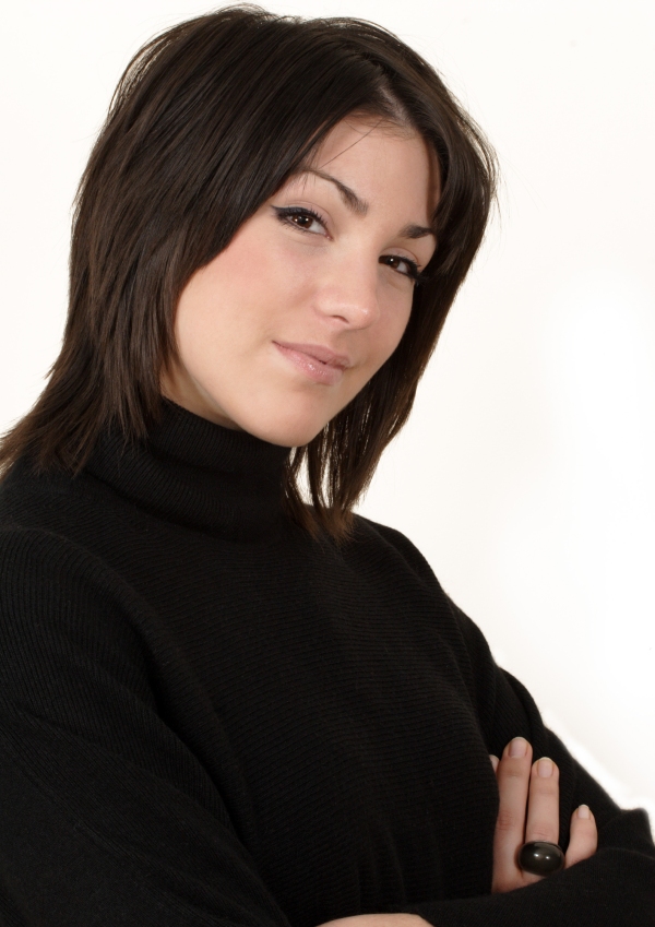 Pretty brunette girl with arms folded smiling at camera