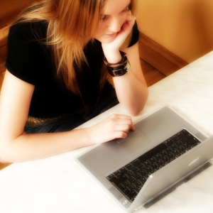 A girl working on a laptop computer seen from above