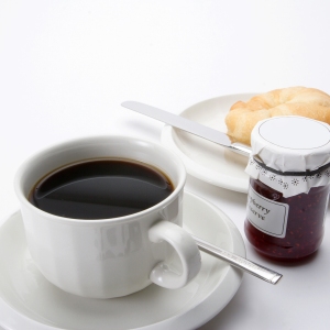 A cup of coffee with some arabica coffee beans, jam and doughnut