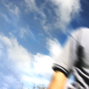 Blurred image of man walking out of shot with blue summer sky in the background