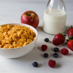 Cornflakes in a bowl with milk and fruits