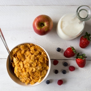 Cornflakes in a bowl with milk and fruits