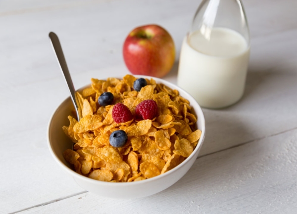 Cornflakes in a bowl with milk and fruits