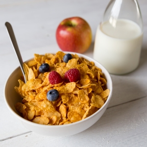 Cornflakes in a bowl with milk and fruits