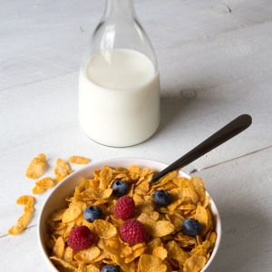 Cornflakes in a bowl with milk and fruits