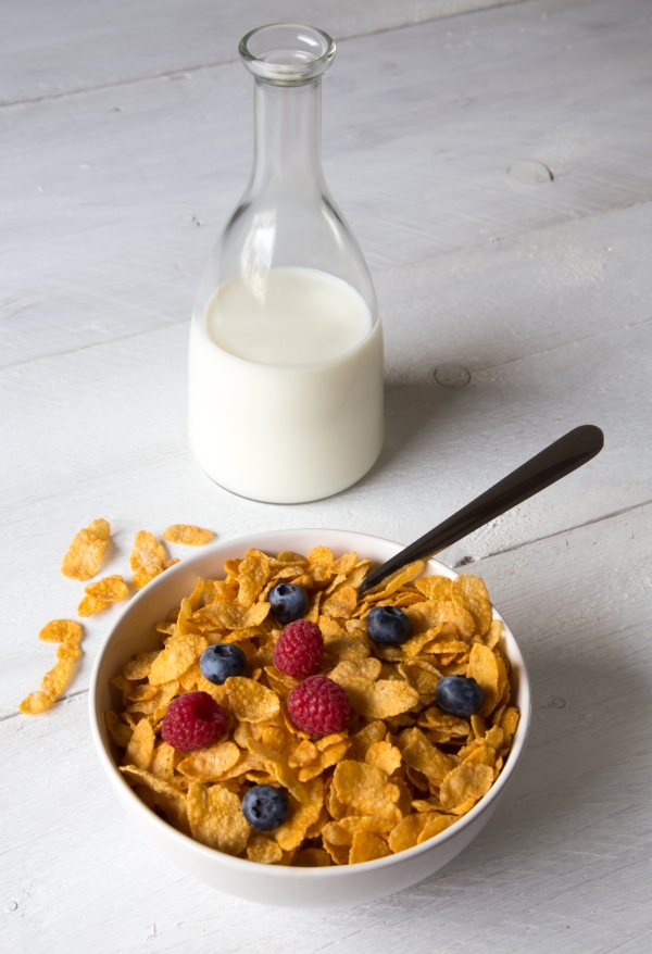 Cornflakes in a bowl with milk and fruits