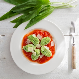 Gnocchi with wild garlic in tomato sauce and parmesan cheese.