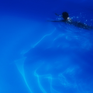 A woman swimming in a blue swimming pool