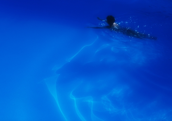 A woman swimming in a blue swimming pool