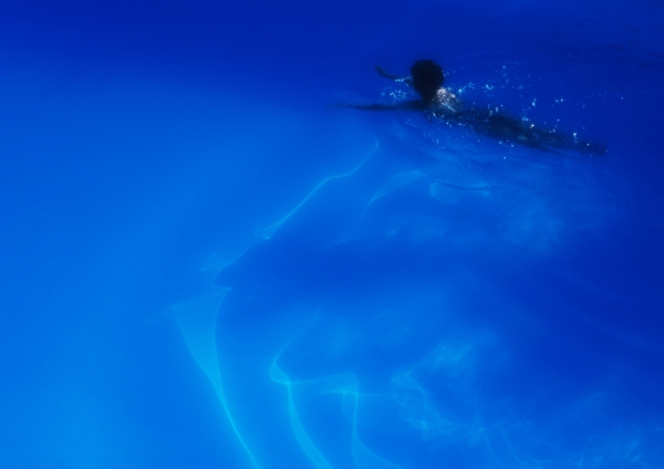 A woman swimming in a blue swimming pool