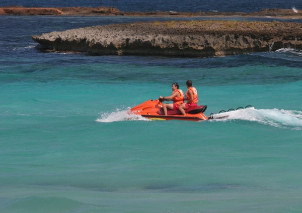 Two men on a speedboat in rough sea