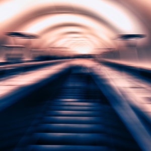 A blurred view of a metro or underground railway escalator in muted colours