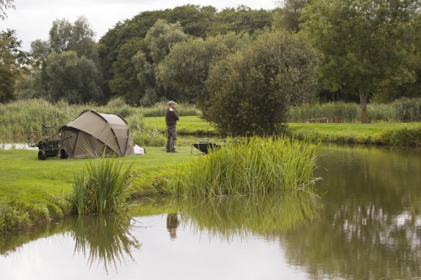 A freshwater angler fishing for carp on a summer's day