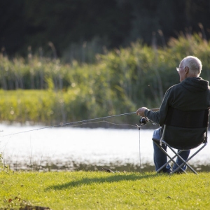 A coarse angler sitting by the river bank or lake side watching for a bite