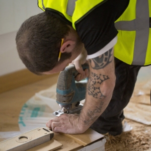 A building site carpenter cutting skirting board