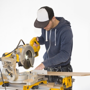 A building site carpenter cutting a wood panel on a cutting table, islolated