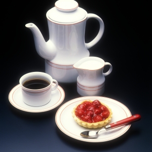 A coffee pot with milk jug and a fruit tart