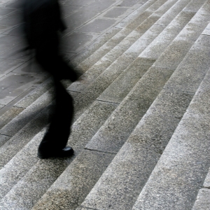 A blurred man walking up steps in the city