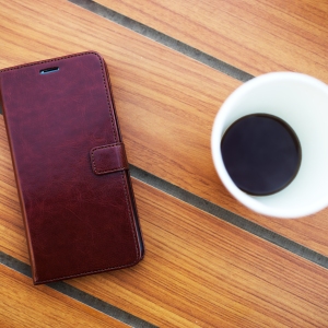 Wooden table in cafe with cell phone and coffee background