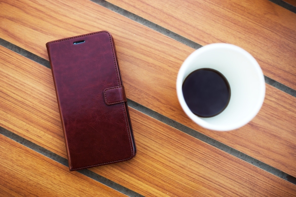 Wooden table in cafe with mobile phone and coffee