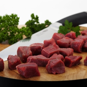 Close up macro shot of chopped steak and carving knife on a chopping board