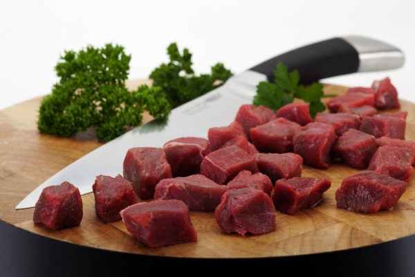 Close up macro shot of chopped steak and carving knife on a chopping board