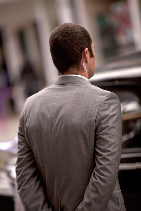 Close protection officer waiting for clients to emerge from a building