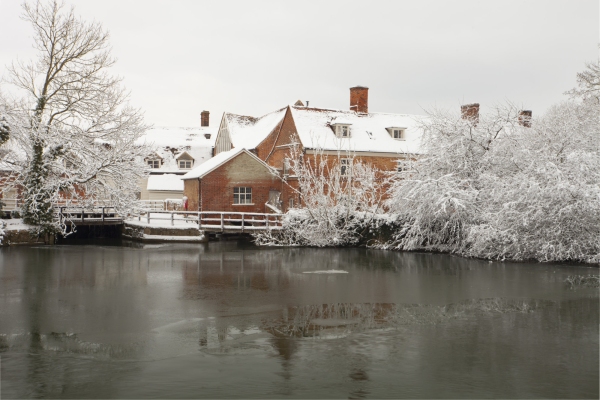 Snow covered Flatford Mill on the River Stour in suffolk