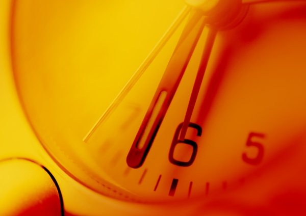 Close up view of an orange tinted clock face