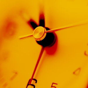 A close up view of an orange tinted clock face