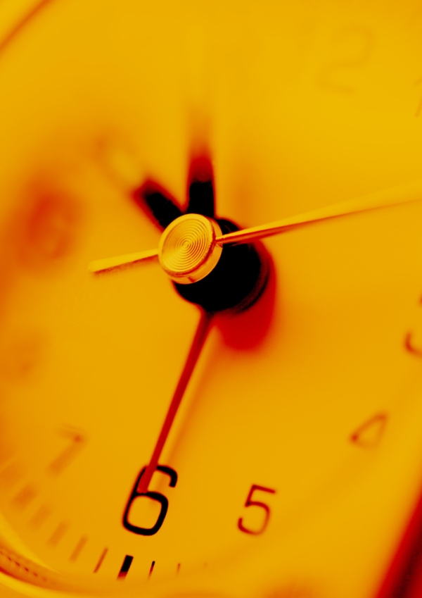 A close up view of an orange tinted clock face