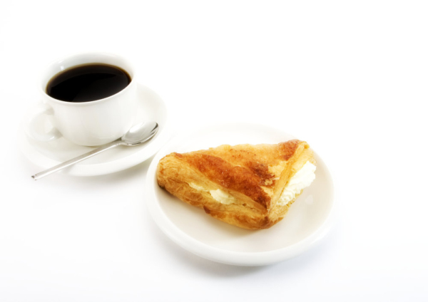 A cup of coffee with a cream filled apple turnover