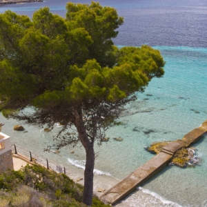 A couple looking at the sea on the end of a stone jetty in Majorca