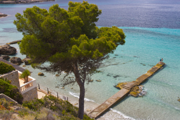 A couple looking at the sea on the end of a stone jetty in Majorca