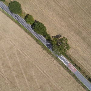 An aerial view of a country road surrounded by cereal crops