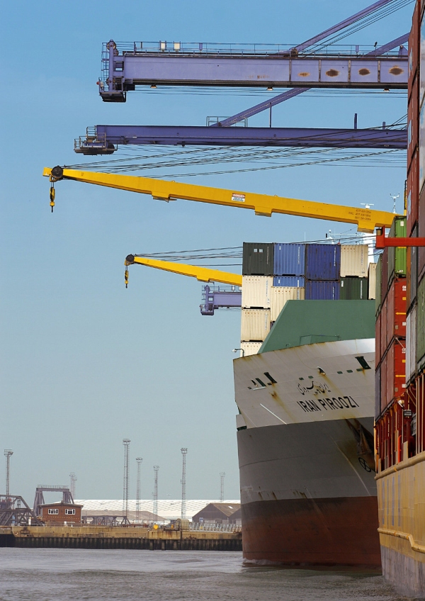 Container ships in the harbour being unloaded by large cranes