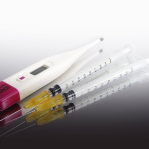 A digital thermometer and two disposable syringes