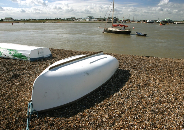 Boats on the shingle and at anchor at Bawdesey in Suffolk