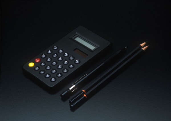 A dark and moody image of a stylish calculator and black pencils